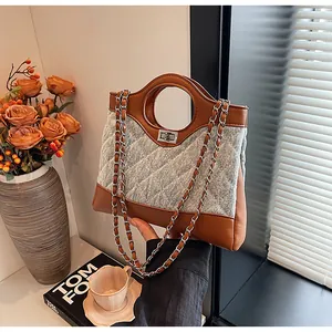 Détail du sac en denim matelassé avec poignée en cuir et fermoir tournant en métal argenté