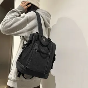 Side view of black washed denim backpack with vintage pleats and adjustable buckles
