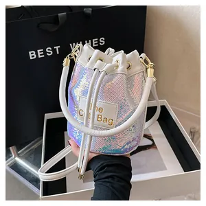 Détail du sac seau à paillettes blanches avec cordon et patch en cuir The Bag