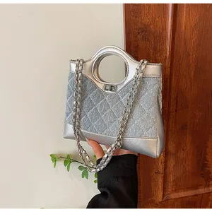 Détail de similicuir argenté matelassé et empiècement denim bleu clair avec chaîne