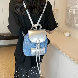 Fashionable mini patchwork backpack in blue denim and silver finish with metal buckles
