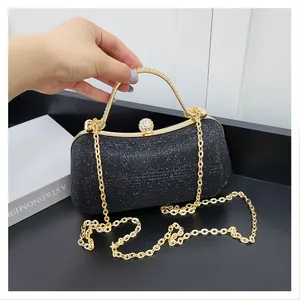 Vue détaillée du sac de soirée noir pailleté avec poignée dorée et fermoir en strass brillant