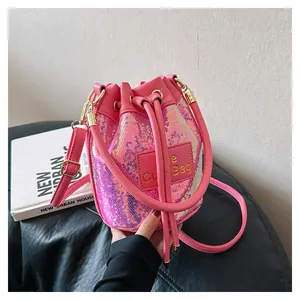 Détail du sac seau à paillettes roses avec cordon de serrage et écusson en cuir Cute Bag