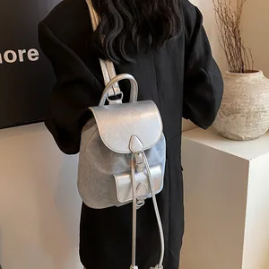 Mini backpack in silver metallic leather and light denim texture on a model shoulder