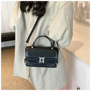 Detail of black handbag showing textured leather contrast and silver heart-shaped metal lock