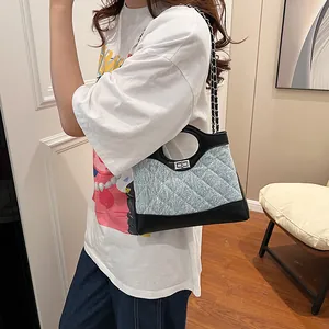 Sac bandoulière chic en jean et cuir matelassé avec fermoir rotatif argenté
