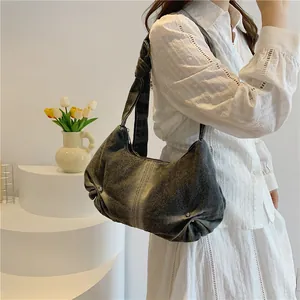 Detail view of the vintage denim hobo bag featuring a stylish knotted wide shoulder strap