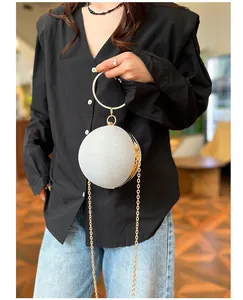 Détail du sac de soirée sphérique pailleté argenté avec poignée anneau doré strass