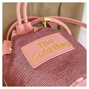 Gros plan détaillé du sac seau à paillettes roses avec logo doré et finitions métalliques