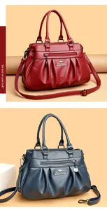 Detailed view of the pleated litchi texture and metal logo on the faux leather handbag