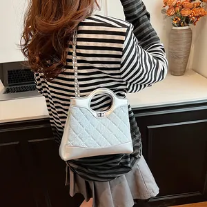 Sac seau matelassé argenté avec paillettes, bandoulière chaîne et fermoir rotatif