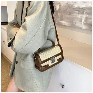 Detail of retro straw and brown leather crossbody bag with silver buckle on green blazer