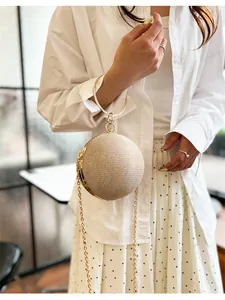 Gros plan sur un sac de soirée sphérique avec tissu pailleté et poignée strass