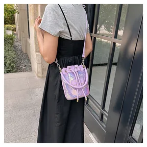 Vue détaillée du sac seau à paillettes violettes avec cordon et étiquette The Cute Bag