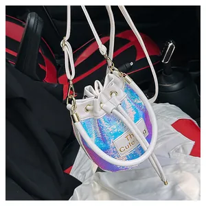 Détail d'un sac seau à paillettes holographiques avec cordon de serrage et logo