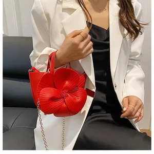 Detail der roten blumenförmigen Handtasche mit Blütenblättern und silberner Kette