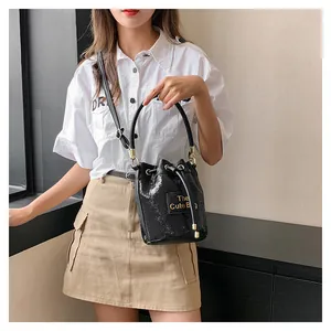 Détail du sac seau à paillettes noires avec lettrage doré et fermeture à cordon
