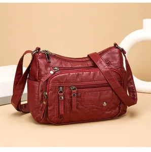 Donkerrode zachte leren crossbodytas met meerdere ritsen en ruitvormige stiksels