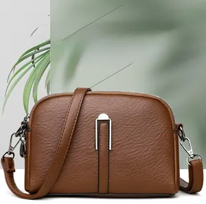 Detailed macro view of brown litchi grain leather shell bag with silver metal hardware