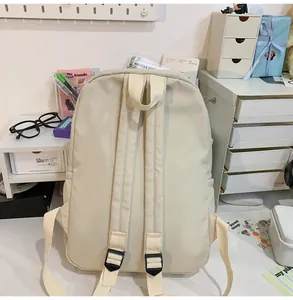 Detailweergave van de achterkant van een crèmekleurige nylon rugzak met brede banden