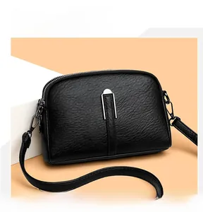 Detail of black lychee grain leather shell bag with silver U-shaped metal hardware and strap