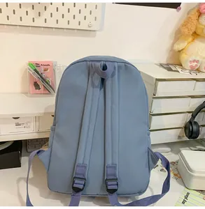 Achteraanzicht van lichtblauwe nylon rugzak met verstelbare riemen op een bureau