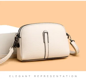 Close-up of cream beige crossbody bag featuring lychee grain leather and double zipper