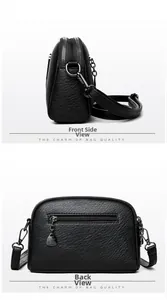 Detail of black litchi grain leather crossbody bag with dual zippers and silver hardware
