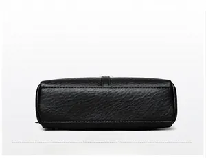 Detailed view of the rectangular base and textured lychee pattern on black leather bag