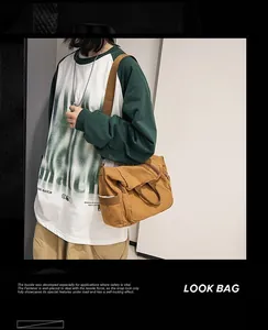 Detailed view of a brown washed canvas crossbody bag with adjustable wide fabric strap