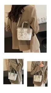 Three views of a white bucket bag with gray butterfly prints and pearl bow charm