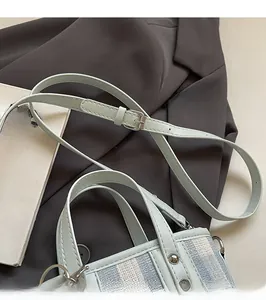 Detail of blue striped patchwork bucket bag with adjustable leather strap and rivets