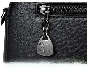 Close-up of litchi grain leather and silver zipper pull with kangaroo logo and MSDS text