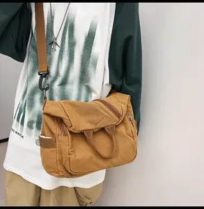 Detailed view of brown washed canvas crossbody bag with adjustable wide fabric strap