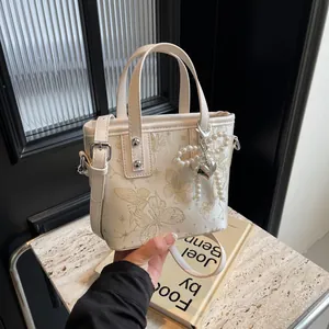 Elegant white bucket bag with butterfly print, pearl charm and detachable shoulder strap