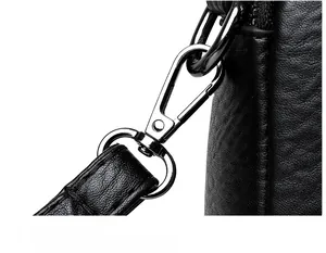 Detailed view of durable gunmetal shoulder strap buckle on black pebble leather bag
