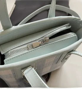 Detailed close-up of smooth silver metal zipper and fine stitching on blue bucket bag