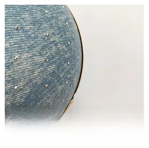 Macro shot of blue denim evening bag showing silver rhinestones and gold metal edge details