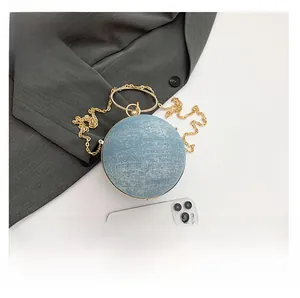 Macro view of blue glitter round evening bag with gold circular handle and metal chain
