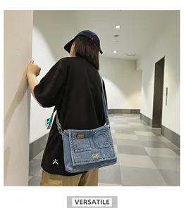 Detailed back view of a blue denim crossbody bag with embossed C letter and flap pocket