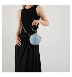 Detail of blue glitter round evening bag with rhinestone handle and gold chain strap