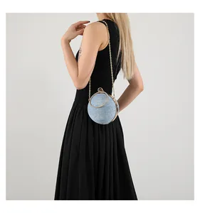 Detail of round spherical evening bag with light blue texture and gold metal ring handle