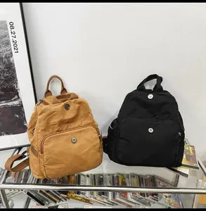 Detailed look at canvas mini backpacks in brown and black with front flap pockets