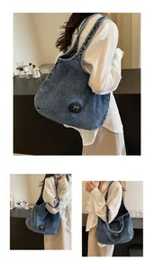 Detail showing washed blue denim tote bag texture with silver bow accents on model