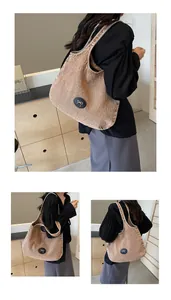 Detail of tan denim tote bag featuring a minimalist white bow patch and wide shoulder strap