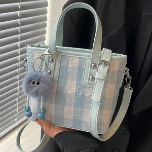 Blue and white plaid crossbody bucket bag with a cute plush monster charm and strap