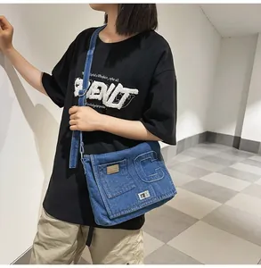 Detailed view of the blue denim crossbody bag featuring a large letter C and metal twist lock