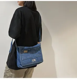 Detail of vintage denim crossbody bag showing silver metal twist lock and embossed C letter