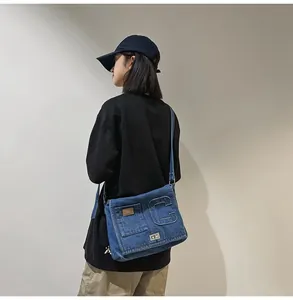 Detailed macro view of washed denim crossbody bag featuring textured letter C patch