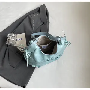 Detail view of the light blue wrinkled tote bag interior with ribbon bow accents